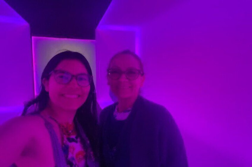 Two people standing in a room with purple lighting. 2