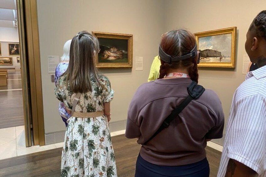People viewing paintings in an art gallery. 1