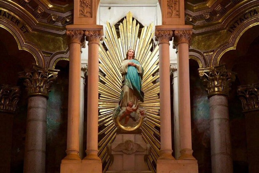 A statue of a religious figure in a grand architectural setting with columns and ornate decorations. 4
