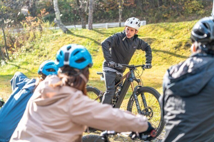 A group of people on a mountain biking trail with a cyclist in the foreground. 2