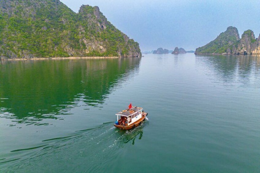 A boat on calm waters with green hills in the background. 2