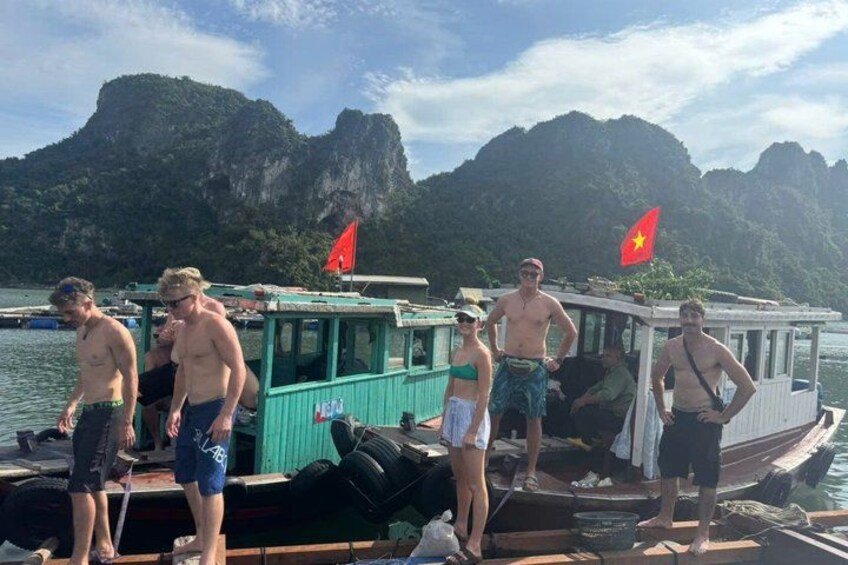 A group of people on a boat with a mountainous landscape in the background. 3