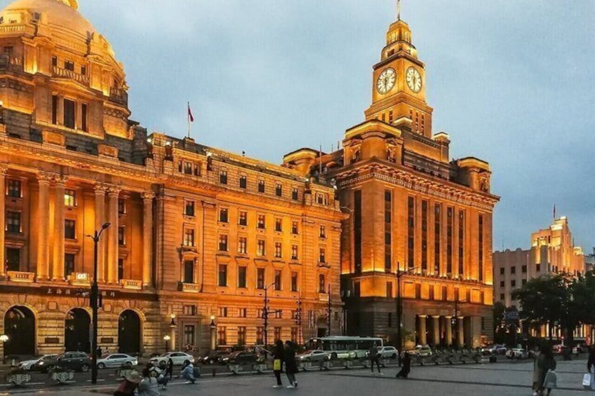 A large, historic building with a prominent clock tower, surrounded by a busy street with cars and pedestrians. 4