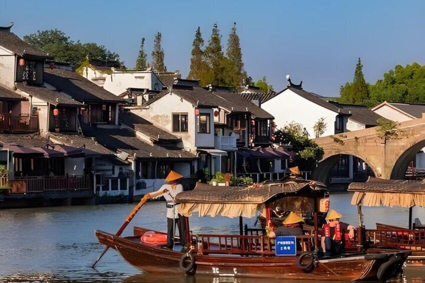 A traditional boat on a river, wooden houses, and a stone bridge. 1