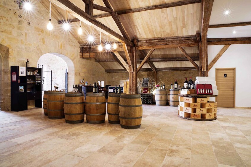 A rustic wine cellar with wooden barrels, a wine rack, and a wooden ceiling. 3