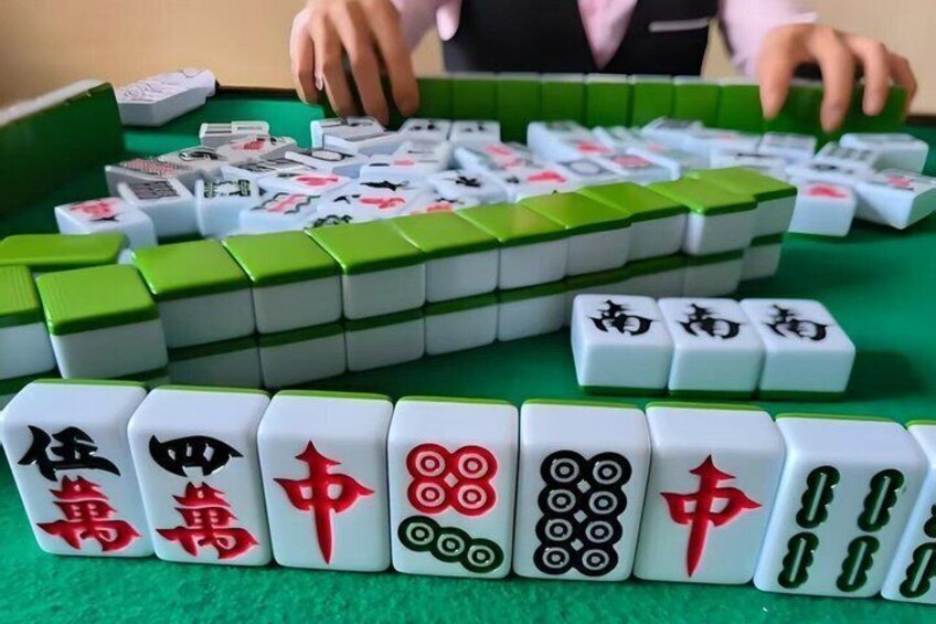 A mahjong table with tiles arranged in front of a player. 3