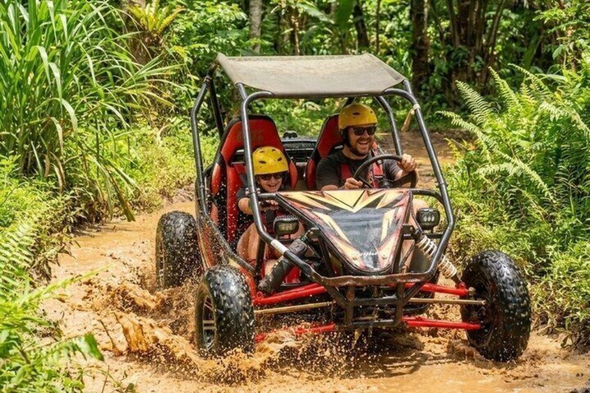 A vehicle navigating a muddy path in a forested area. 3