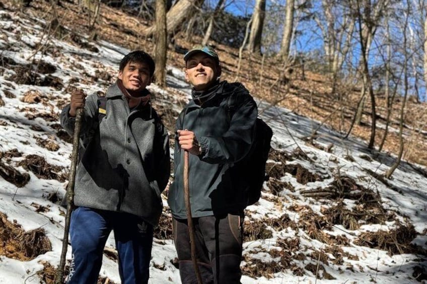 Two people hiking in a snowy forest. 2