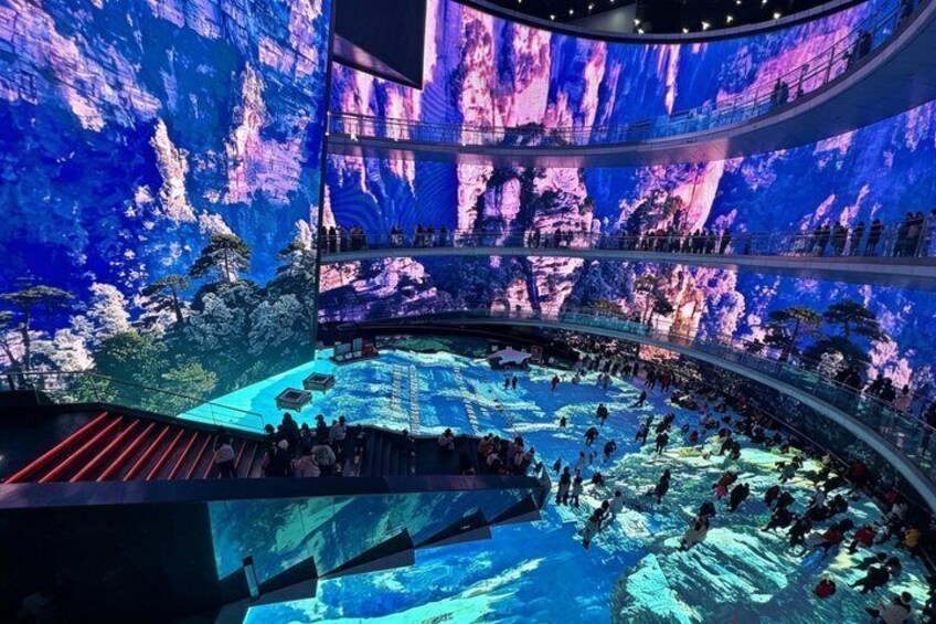 A large indoor venue with a central pool and tiered seating. 3