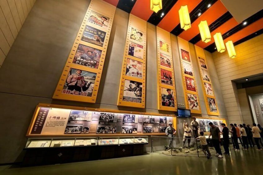 A museum with large posters and a display case. 2