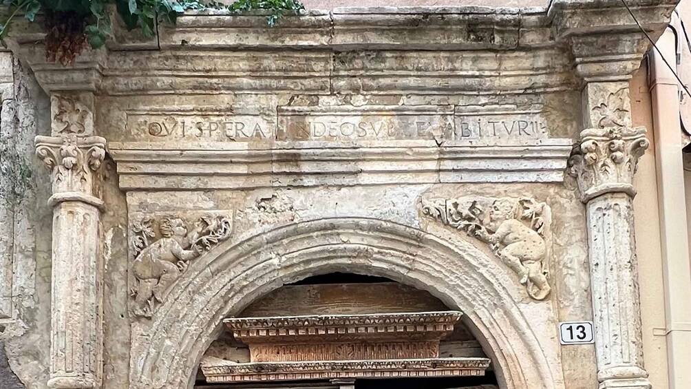 A stone archway with inscriptions and decorative carvings. 2