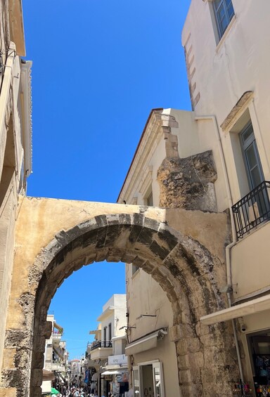 An arched stone gateway in a narrow street with buildings on either side. 5