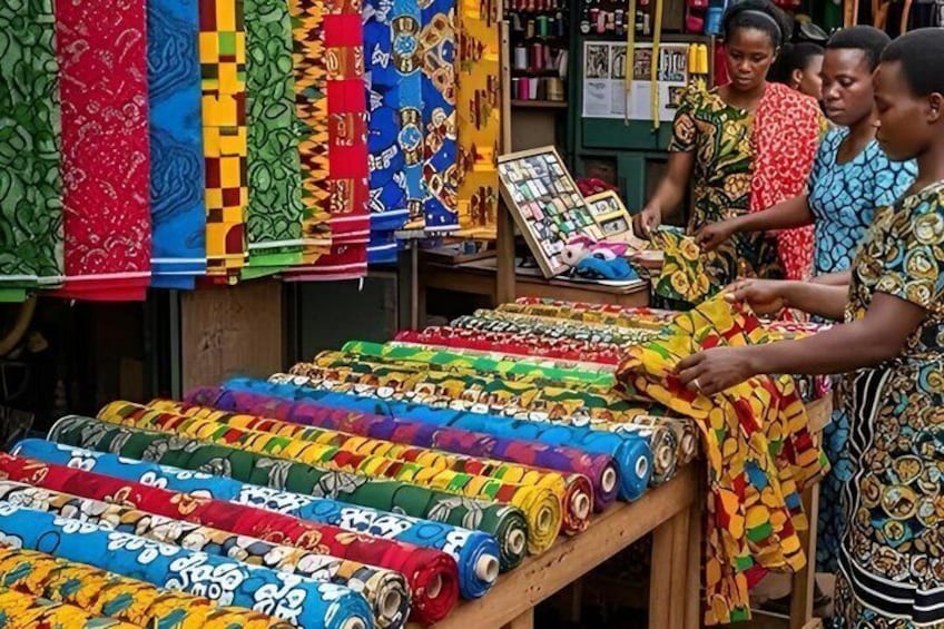 A market stall with colorful fabrics and rolls of fabric. 2
