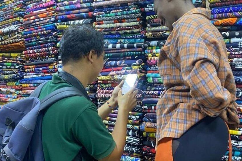 A person taking a photo of another person in a fabric store. 3