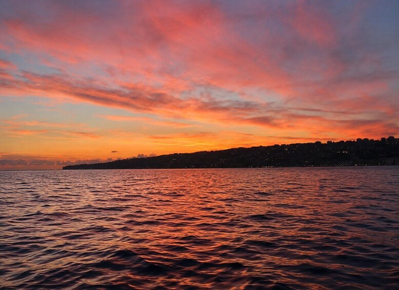 A sunset over a body of water with a city skyline in silhouette. 3