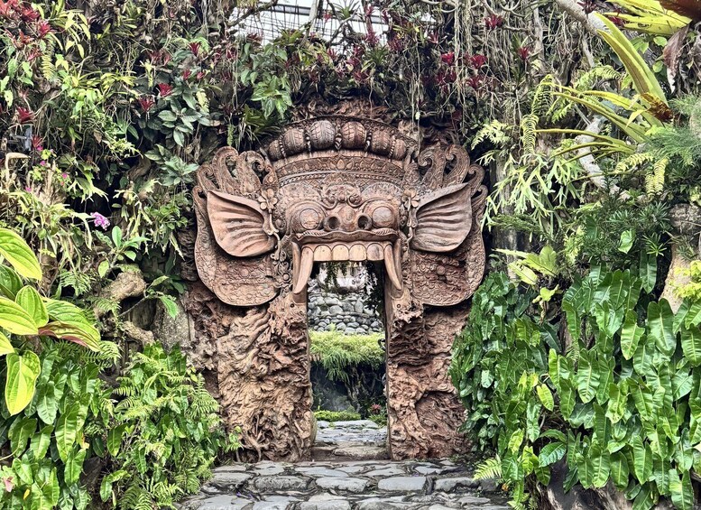 A stone archway with intricate carvings, surrounded by lush tropical foliage. 2