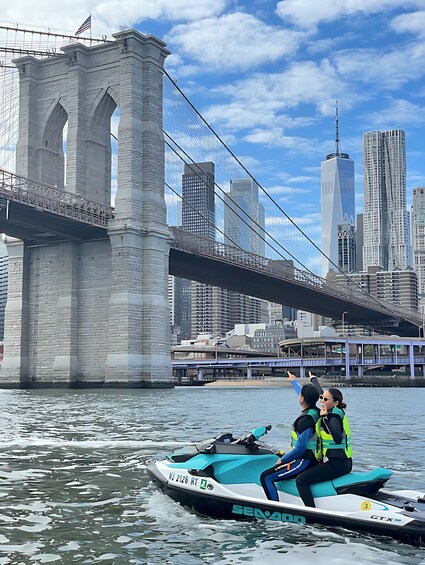 A jet ski on water with a bridge and city buildings in the background. 4