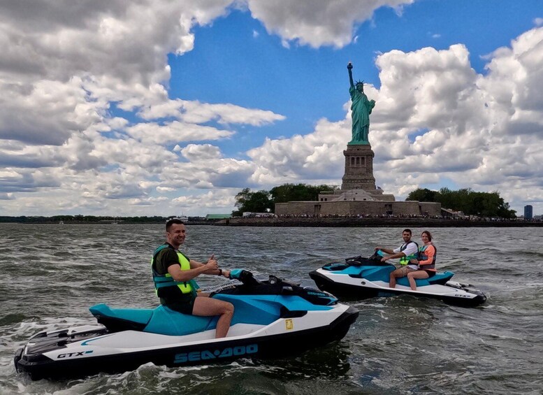 Two people on jet skis with the Statue of Liberty in the background. 5