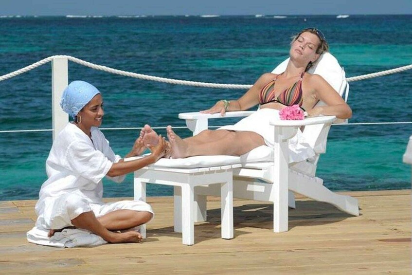 A person receiving a massage on a beach chair with the ocean in the background. 1