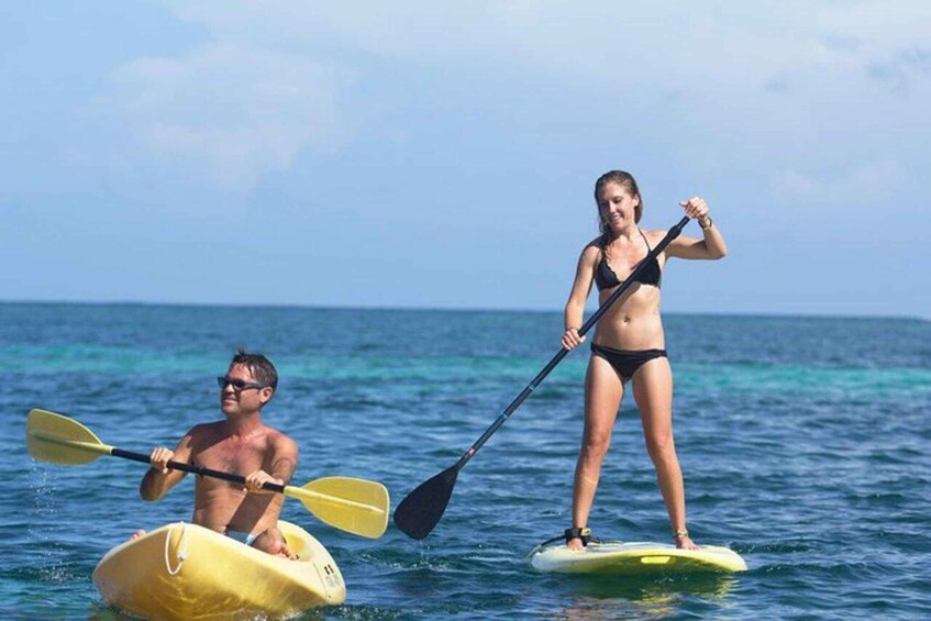 Two people paddleboarding on a calm sea with clear skies. 3