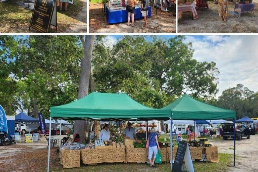 A market with green tents and tables displaying goods. 5