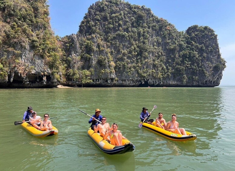 People in inflatable rafts on a calm river with a mountainous backdrop. 4