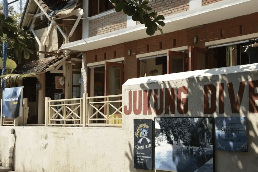 A building with a sign reading 'JUKUNG DIVES' and a poster advertising 'Specialty for Kids.' 2