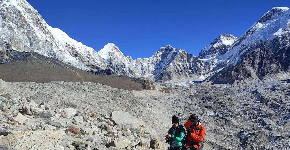 A mountainous landscape with rocky terrain and snow-capped peaks under a clear blue sky. 2