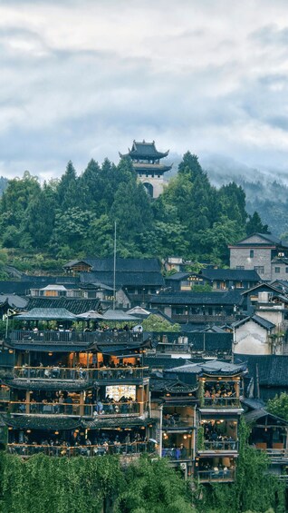 A traditional Chinese village with tiered buildings, a pagoda, and lush greenery. 2