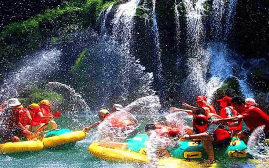 People rafting on a river with a waterfall in the background. 4