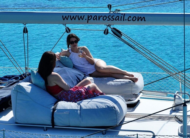 Two people relaxing on a sailboat with a clear blue sea in the background. 2