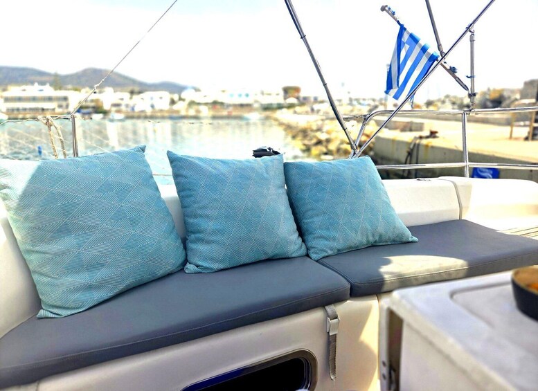 A boat's interior with three patterned cushions and a flag. 4