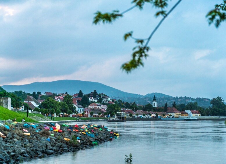 A riverside town with colorful boats, a church, and a mountain in the background. 3