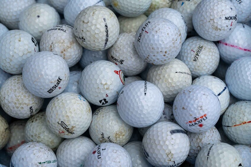 A collection of golf balls with various brand markings. 3