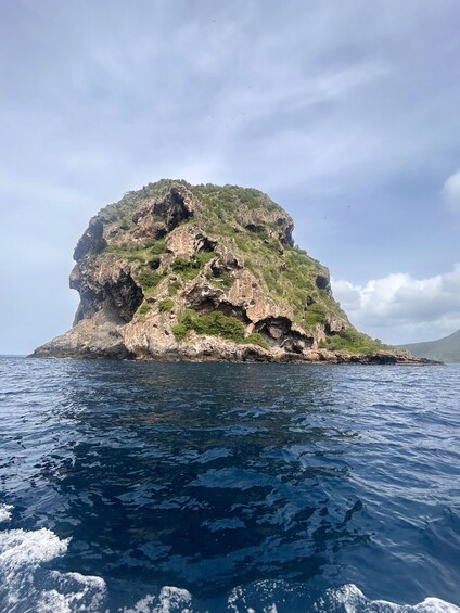A rocky island surrounded by deep blue sea. 3