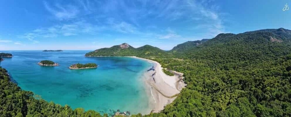 A coastal landscape with a beach, clear turquoise waters, and lush green hills. 1