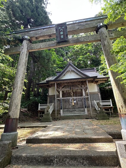 A traditional Japanese building with a wooden torii gate in front. 4