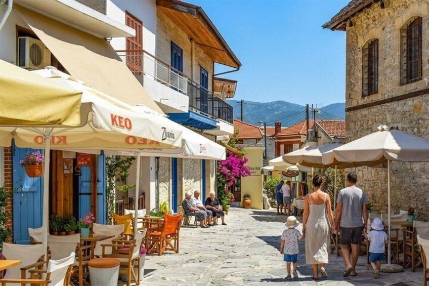 A cobblestone street with outdoor seating, cafes, and stone buildings. 3