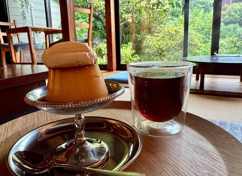 A dessert on a silver tray, a glass of red beverage, and a wooden table with chairs. 2