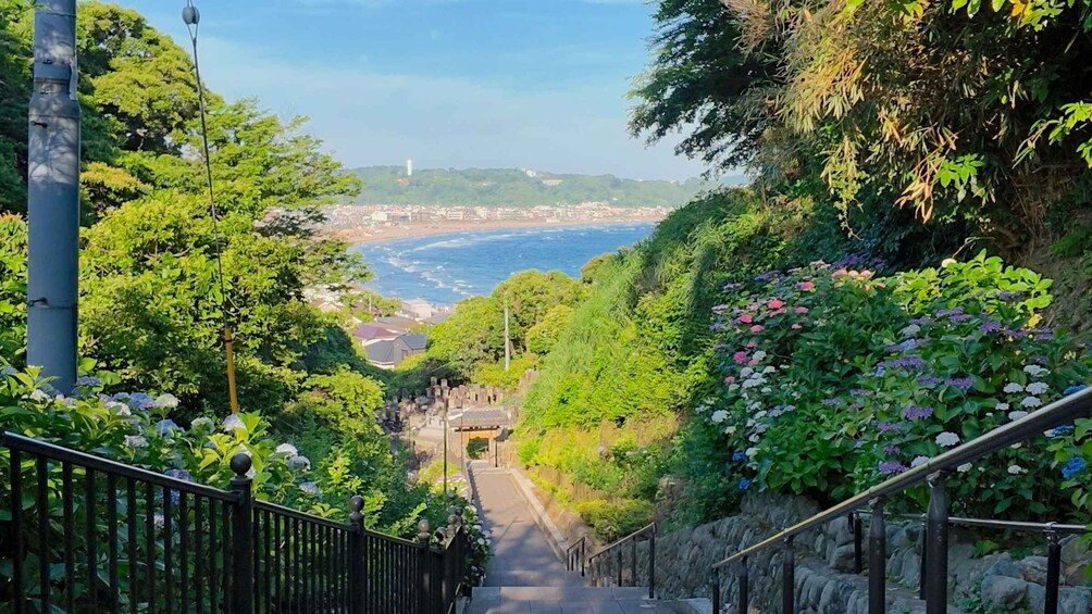 A staircase leading to a coastal cityscape with a lighthouse in the distance. 1