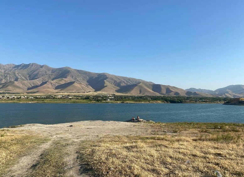 A lake with mountains in the background and a clear sky. 1