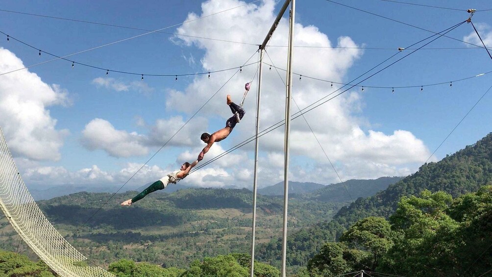 A person performing an aerial acrobatic maneuver on a high wire. 2