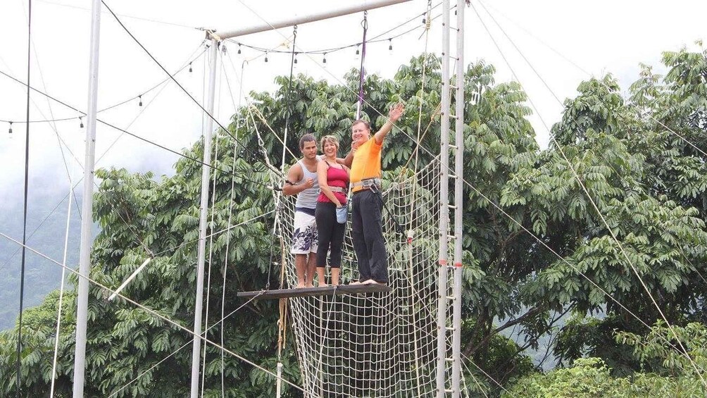 A group of people on a rope bridge in a forested area. 4