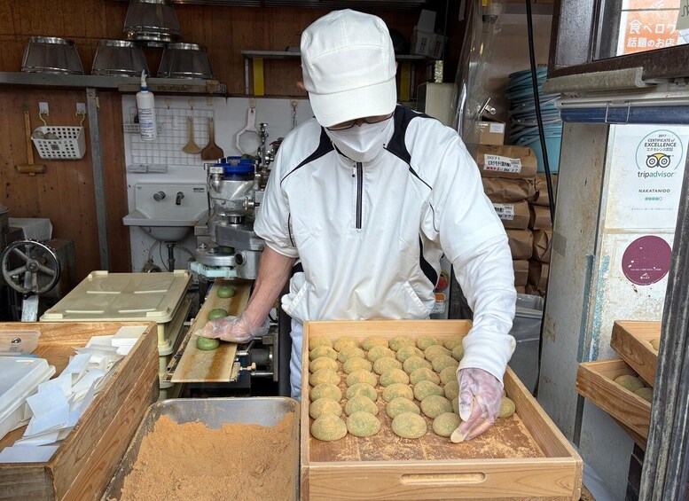 A person in a white uniform working with food items in a kitchen setting. 5