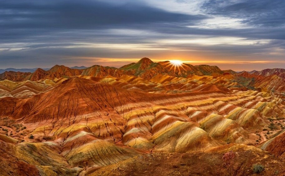 A landscape of layered rock formations with a sunset in the background. 1