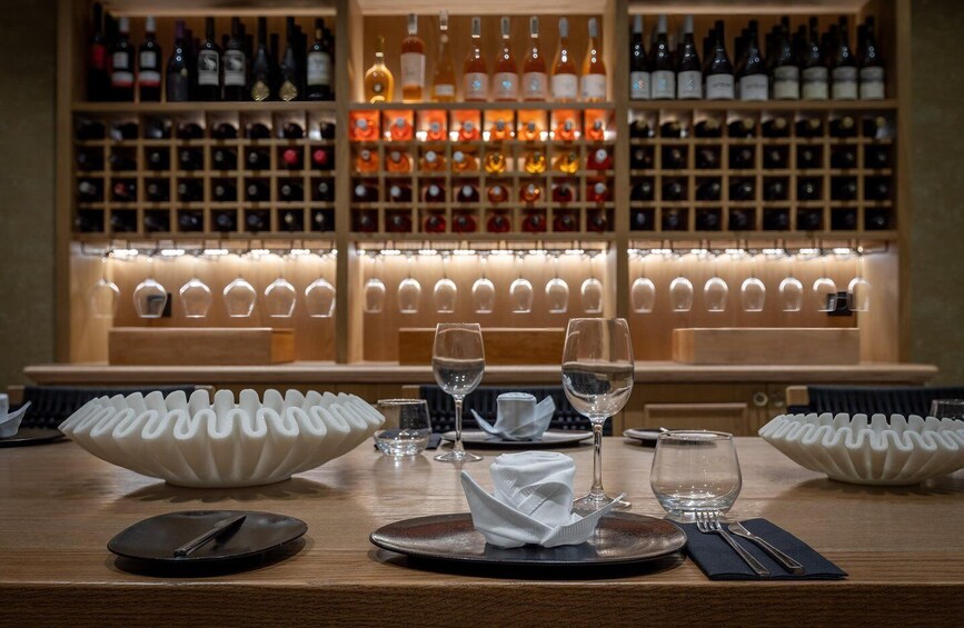 A bar with neatly arranged wine bottles and glasses. 2