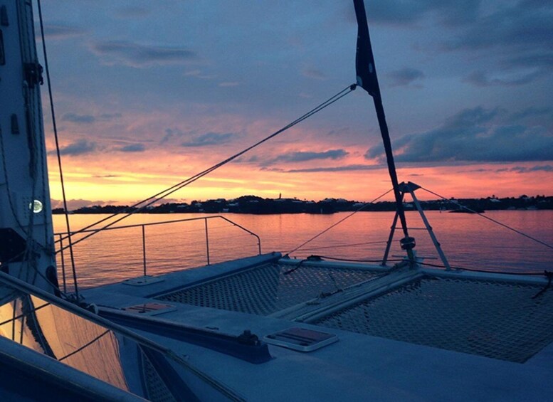 A sailboat with a view of a sunset over calm waters. 3