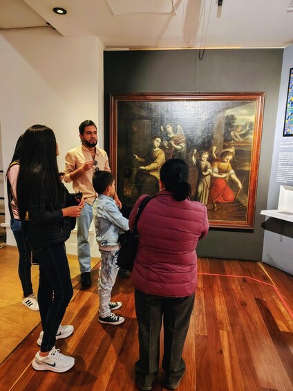 A group of people observing a large painting in a museum. 3