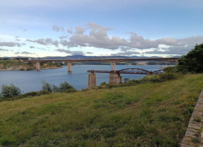 A bridge over a river with hills in the background. 3