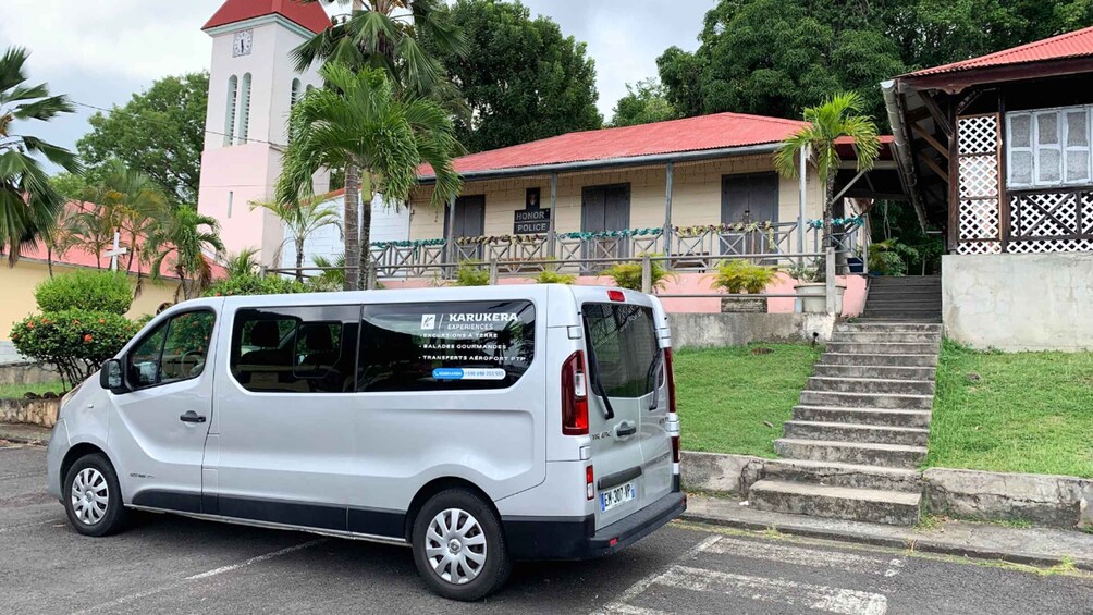 A silver van parked in front of a building with a red roof and a sign that reads 'HONOR POLICE.' 3
